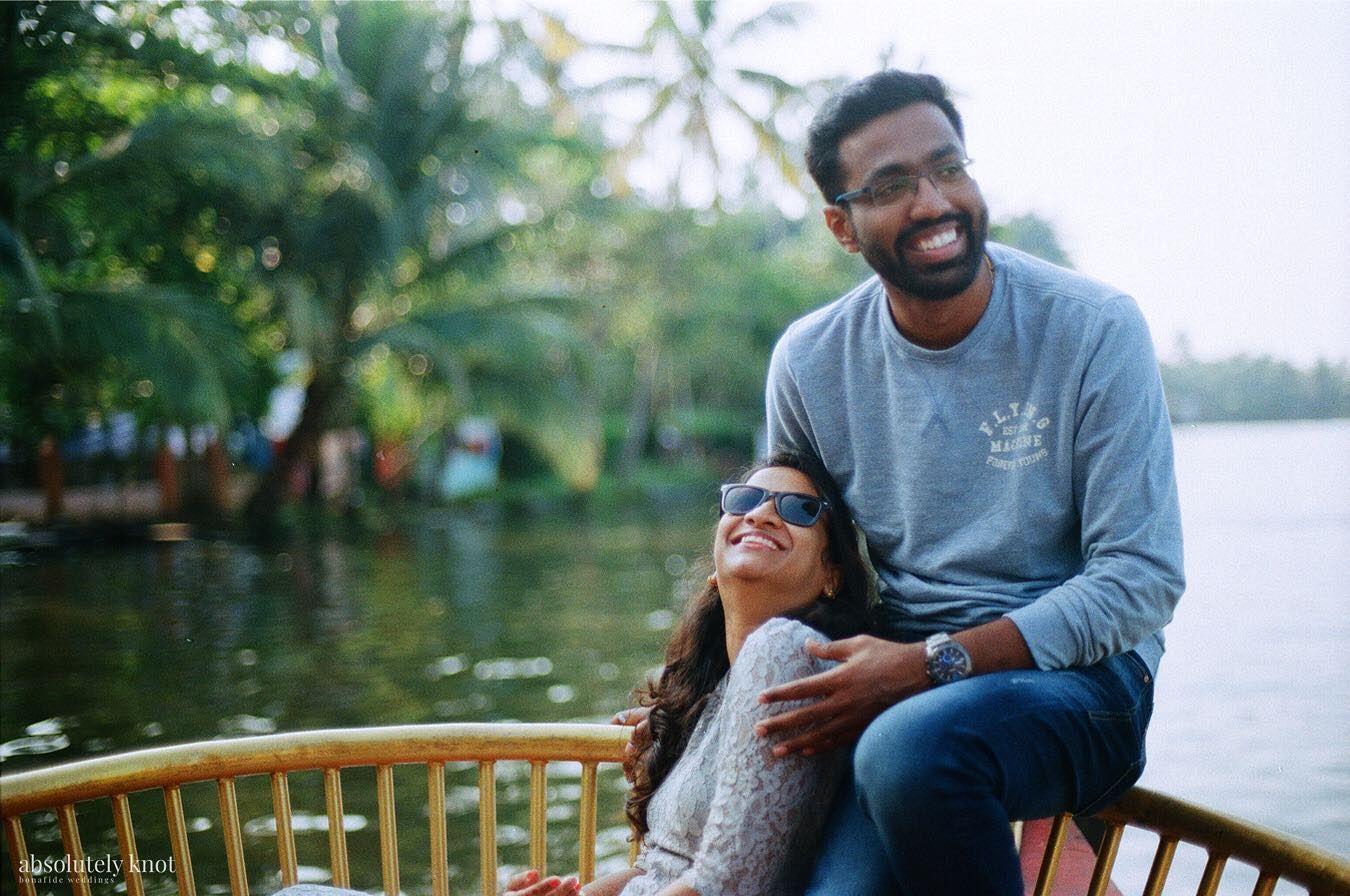 A couple laughing on the deck of a boat on the backwaters, shot on 35mm Kodak film