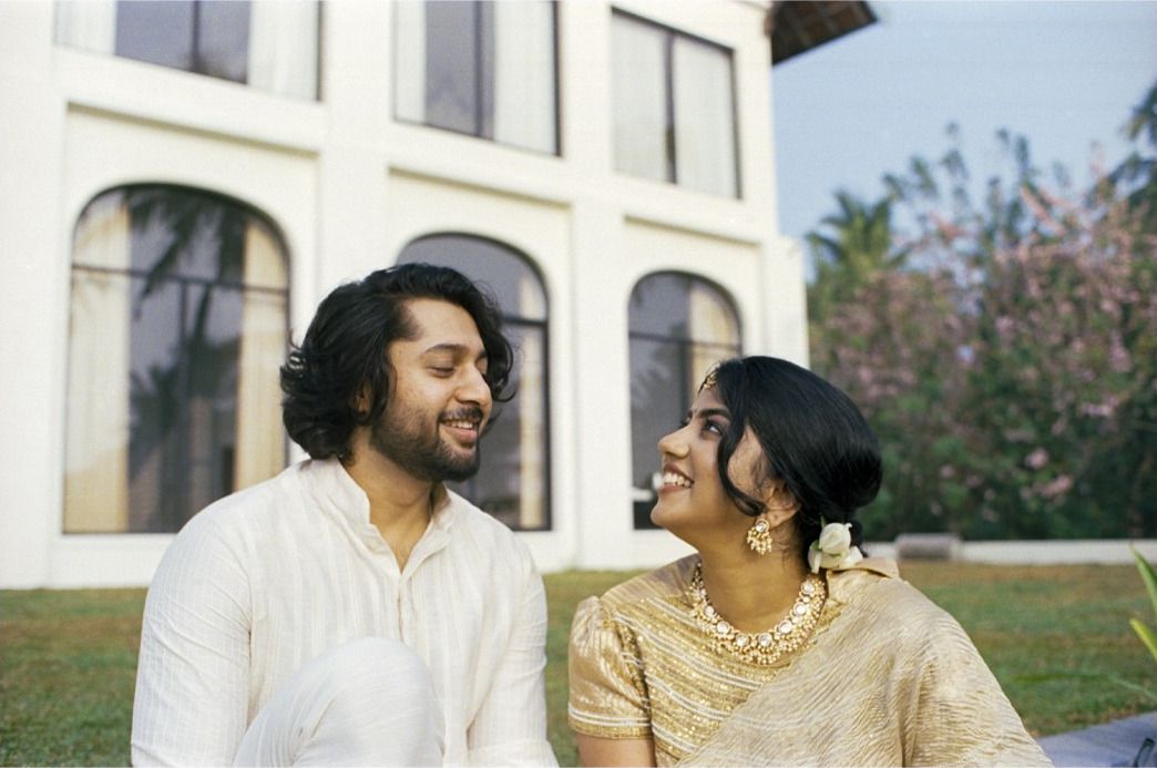 Shebin and Mikhiya laughing together on a lawn, shot on 35mm film