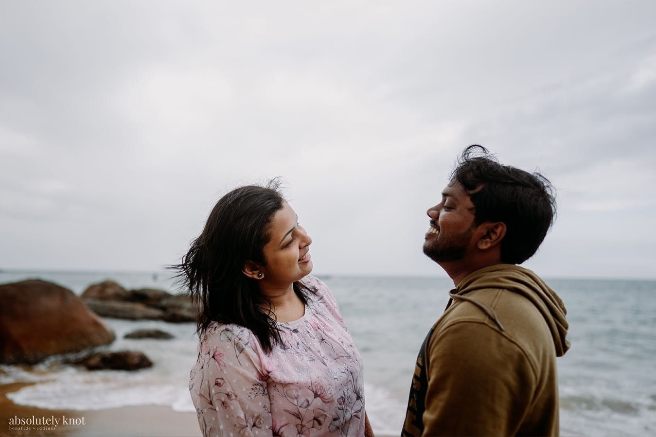 A couple talking by the sea on an overcast day